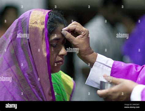 An Indian Catholic Priest Marks Cross Symbol On The Forehead Of