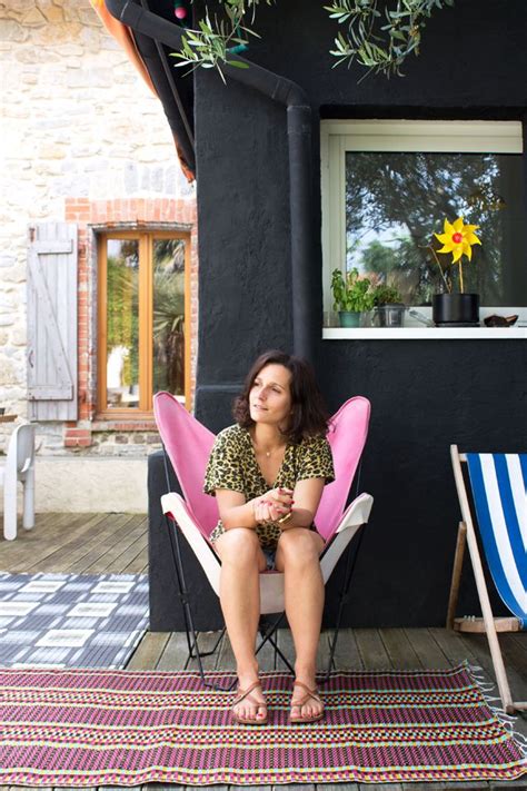 A Woman Sitting In A Pink Chair On Top Of A Rug