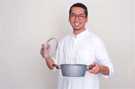 Premium Photo Adult Asian Man Smiling Happy While Holding A Cooking Pot