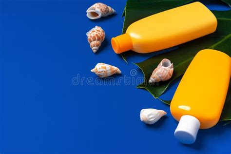 Bright Yellow Bottles Of Sunscreen Product On Dark Blue Paper