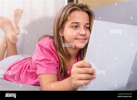 Teenage Girl Reading A Book Lying On The Couch Stock Photo Alamy