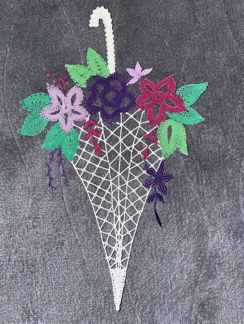 An Umbrella Decorated With Flowers And Leaves On A Gray Sweater Fabric