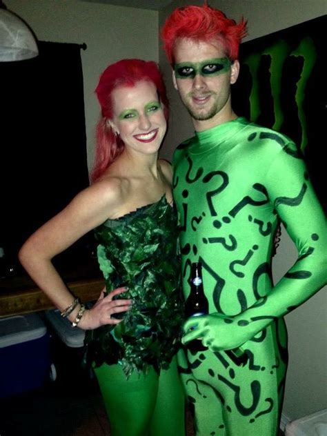 A Man And Woman Dressed Up In Green Costumes Posing For A Photo With