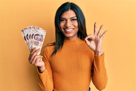 Joven Transexual Latina Transexual Mujer Sosteniendo Billetes De Pesos Mexicanos Haciendo Ok