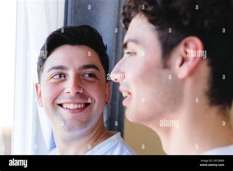 Couple gay partageant un moment spécial le matin par la fenêtre Tendresse romantique