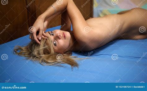 Modelo Nude Que Levanta Na Cama Foto De Stock Imagem De Postura