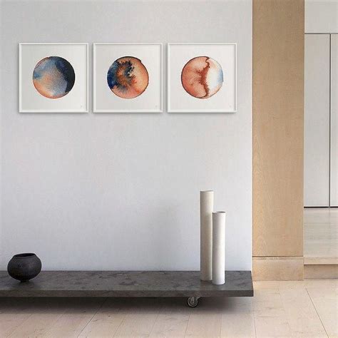 Three Paintings Hang On The Wall Above A Table