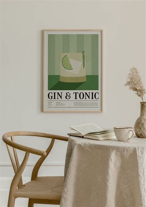 A Table With A Book And Vase On It Next To A Wall Mounted Gin And Tonic Poster