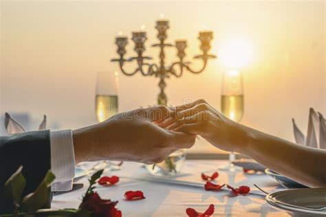 Casal De Mãos Dadas Jantando No Restaurante à Vista Do Pôr Do Sol