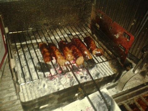 Some Meats Are Cooking On A Grill In The Dark With Red Paint All Over It