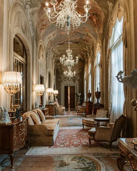 An Ornately Decorated Hallway With Chandeliers And Couches