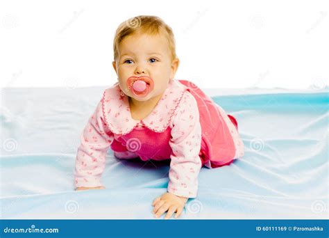 Baby Girl With Pacifier Crawling On The Blue Coverlet Studio Stock