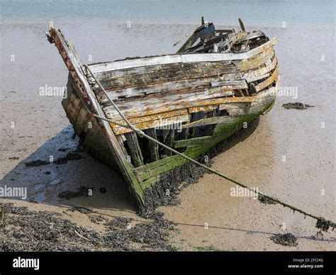 Derelict And Rotting Wooden Boat Have Submerged In Silt At Low Tide On