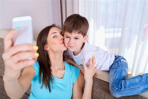 Madre Joven Y Su Hijo Que Toman Un Selfie En El Sof Fami Feliz Foto De