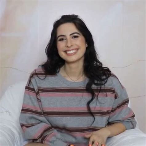 Smiling Woman on Bed with Remote Control and Cell Phone