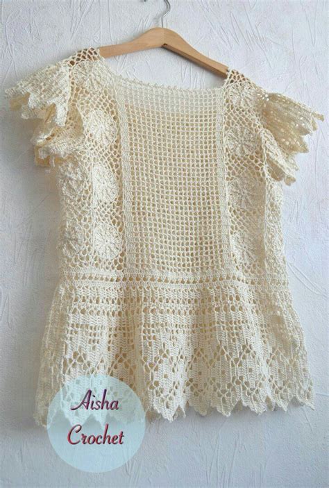 A White Crochet Top Hanging On A Wooden Hanger