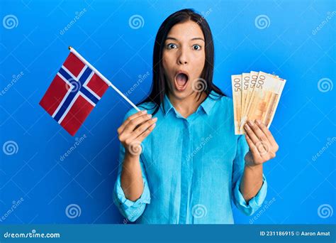 Jovem Latina Segurando A Bandeira Da Noruega E Notas De Coroa Medo E Chocada Surpresa E