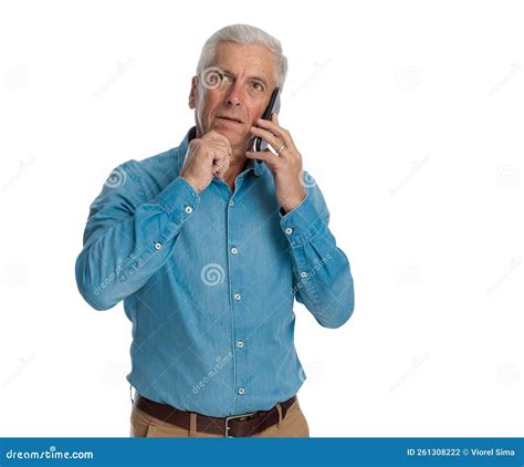 Thoughtful Old Man Talking On The Phone And Thinking Stock Photo