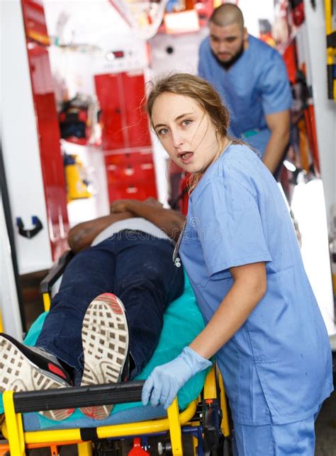 Vigorous Ambulance Team Providing Medical Care To Male Patient In