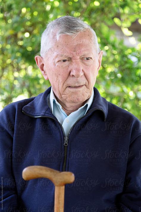 Portrait Of A Pensive Senior Men Sitting In His Backyard By Stocksy