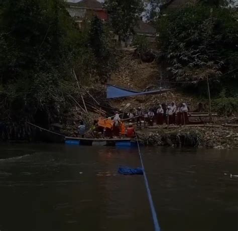 Warga Nekat Menyeberangi Sungai Dengan Perahu Getek Saat Jembatan