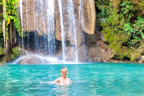 Mujer joven pelirroja en traje de baño bikini rosa se relaja en el lago
