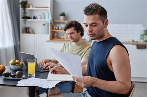 Retrato De Una Joven Pareja Gay Que Vive Junta Con El Foco En El Hombre Que Estudia En La Mesa
