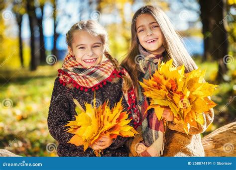 Two Cute Smiling 8 Years Old Girls Posing Together In A Park On A Sunny