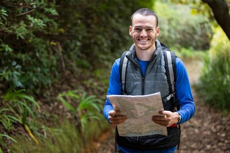 Alpinista Masculina Segurando Um Mapa Na Floresta Foto Premium