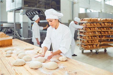 Una mujer panadero sonríe con sus colegas en una panadería 2023