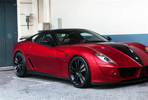 a red sports car is parked in a parking lot next to a blue wall and door