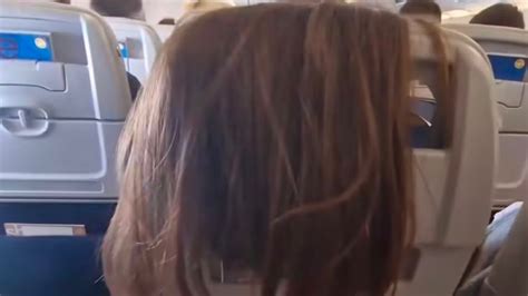 Passenger Lets Her Hair Down In Front Of A Womans Seat On Flight