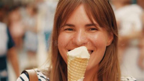 Mujer Joven Feliz Que Come El Cono De Helado Y Que Camina Abajo De La