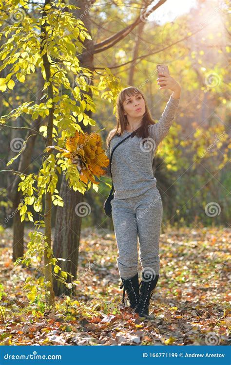 Beautiful Girl Takes Pictures On The Phone In The Autumn Park Selfie