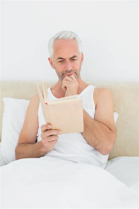 Relaxed Mature Man Reading Book In Bed Stock Photo Image Of