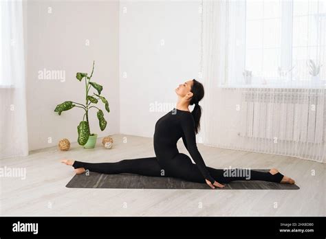 Una Mujer De Ropa Deportiva Negra Que Practica Yoga Realiza El