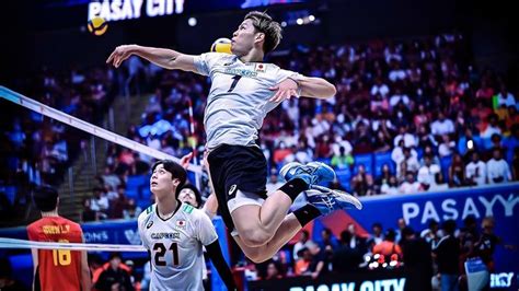 A Volley Ball Player Jumping Up To Hit The Ball With His Racket In