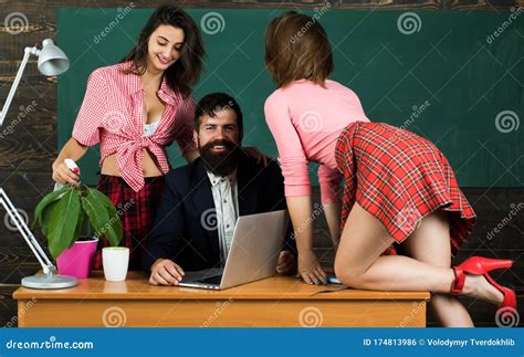 Sexology Teacher Looks At Two Female Students Erotic Education And Sex Symbols On Chalkboard