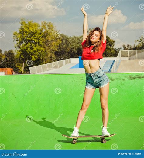 Beautiful Brunette Girl Posing On The Ramp Skate Park Standing On A Skateboard Stock Photo