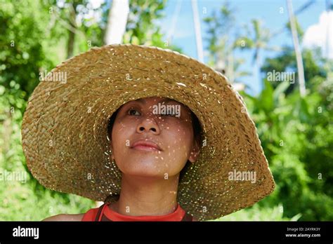 Close Up Portrait Of An Asian Woman Wearing A Big Straw Hat In Bright