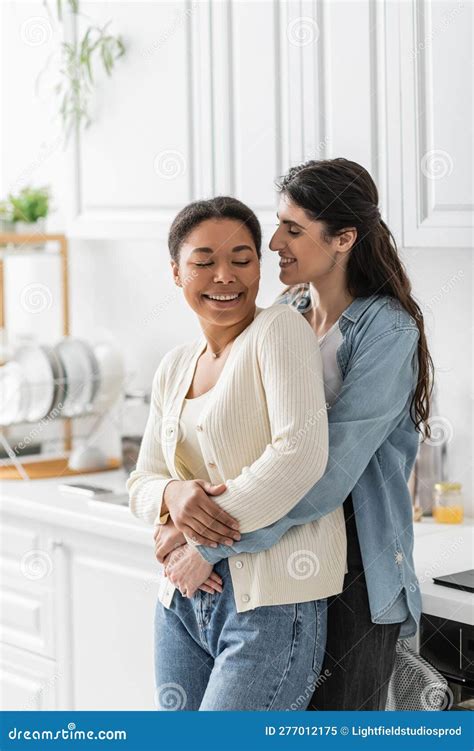 Cheerful Lesbian Woman Hugging Multiracial Girlfriend Stock Image