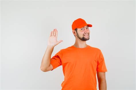 Free Photo Delivery Man In Orange T Shirt Cap Showing Palm And