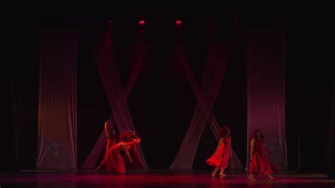 Silhouetted Dancers On Stage With Dramatic Red Lighting And Shadows