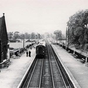 Black And White Photograph Of Train Tracks With People Standing On The