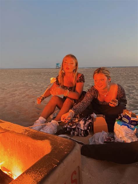 Two Women Sitting Next To Each Other On The Beach