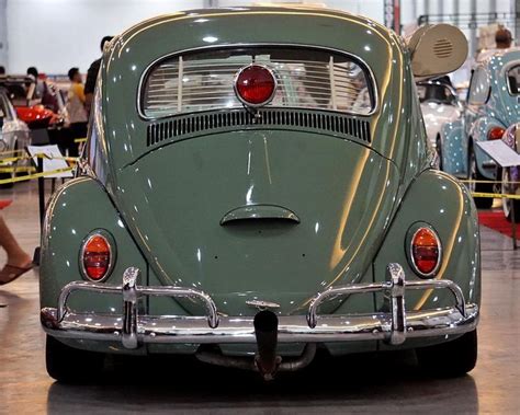 An Old Green Vw Bug Parked In A Showroom