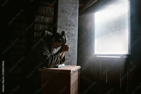 Man Praying To God In Dark Room With Ray Of Light Stock Photo Adobe Stock