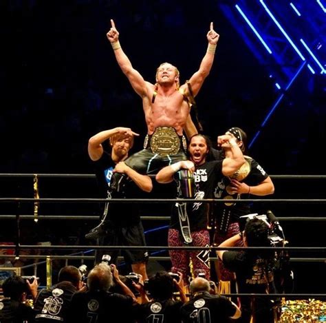 Two Men Standing On Top Of Each Other In The Middle Of A Wrestling Ring