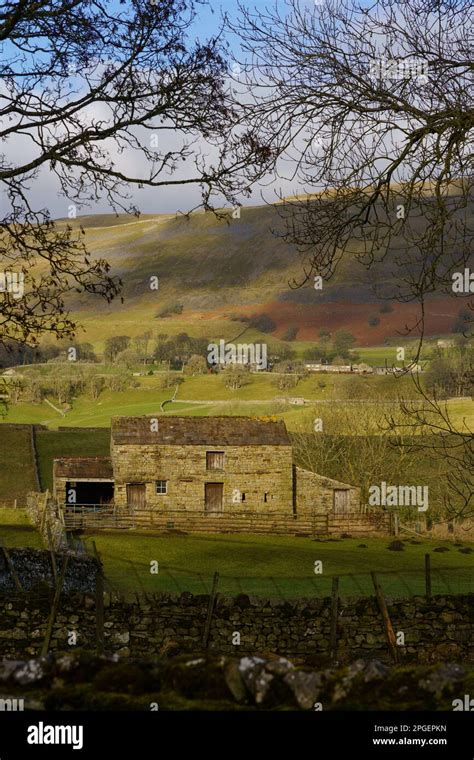 Ramshackle Old Farmhouse Located In A Valley Illuminated By Wintry