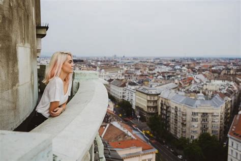 Premium Photo Blonde Girl Looking Over The City From A Balcony In Daylight